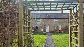 A stone building with a gravel path leading to a wooden gate. - 3 Bed in Alnwick (oc-94195) (Christon Bank)
