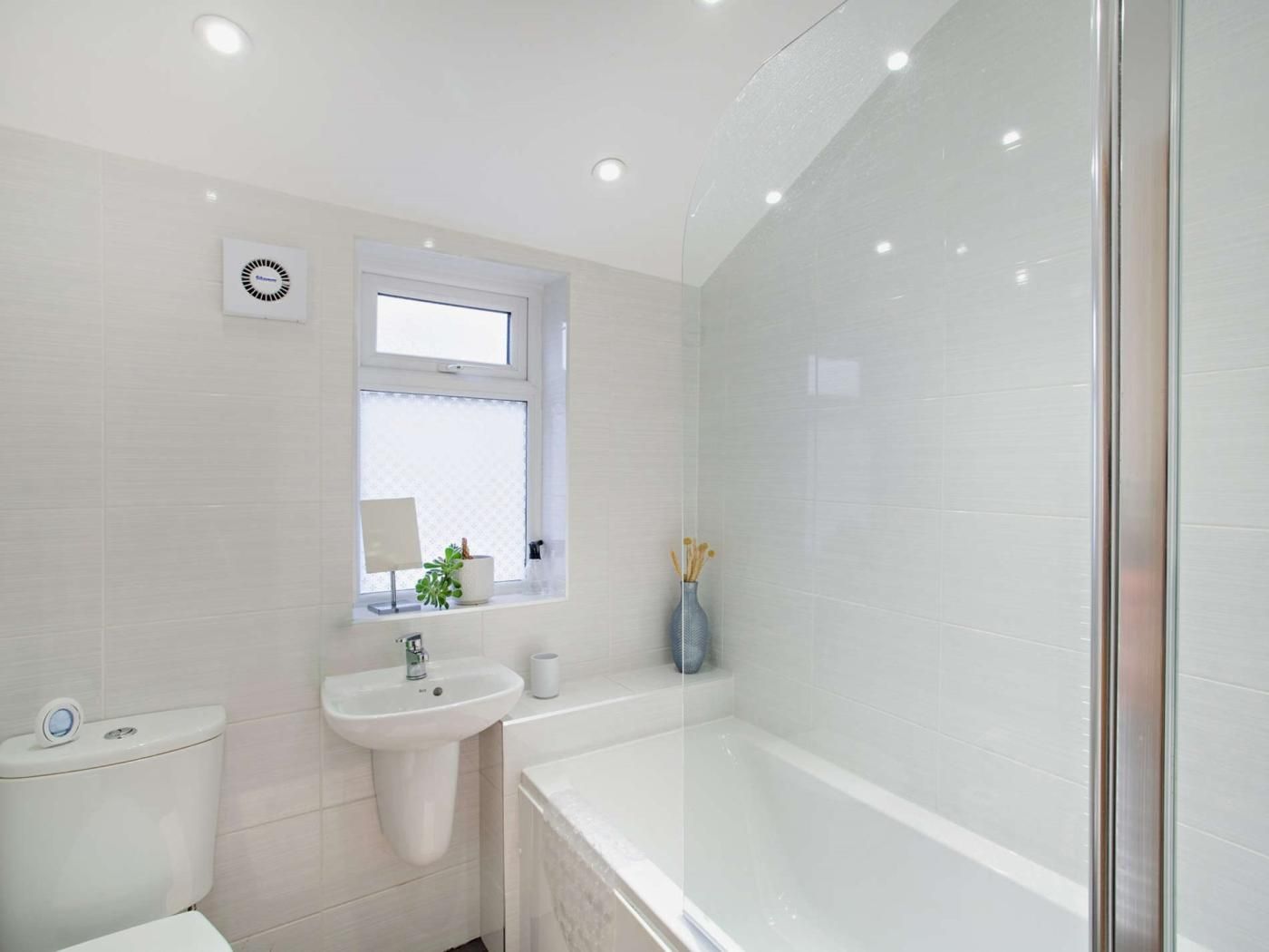 A modern bathroom with a toilet, sink, and bathtub.