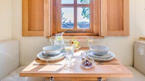 A dining table with plates, bowls, a pitcher, and a glass set against a window with wooden shutters. - 1 Bed in Leominster (oc-93060) (Pembridge)