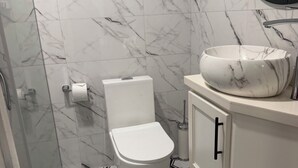 A bathroom with a toilet, a sink, and a mirror. - Relax in luxury and sleep in peace. (Discovery Bay)