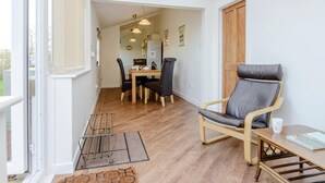 Una habitación con comedor, una silla, una mesa y una puerta.