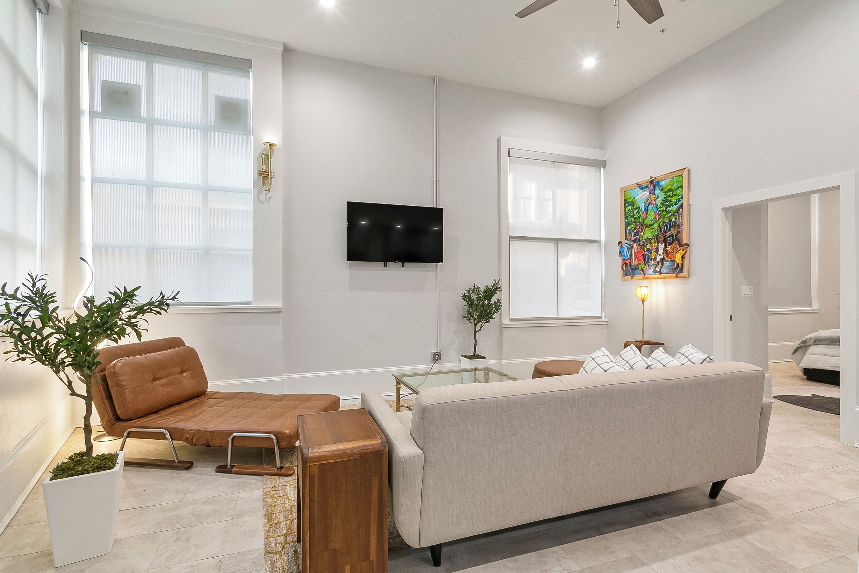 Una sala de estar moderna con un sofá, una mesa de centro y un televisor montado en la pared.
