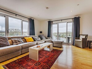 A modern living room with a leather sofa, a white coffee table, and a red patterned rug. - 4 Bed in Newport (oc-94556) (Whippingham)