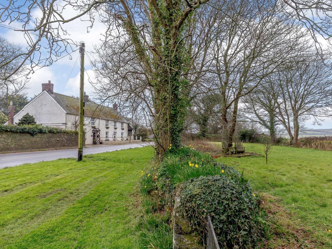 A rural setting with a house, a grassy field, and a tree.