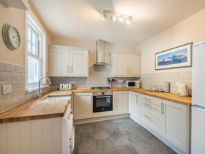 A modern kitchen with white cabinets, a microwave, a toaster, and a sink. - 2 Bed in Keswick (oc-sz250) (Braithwaite)