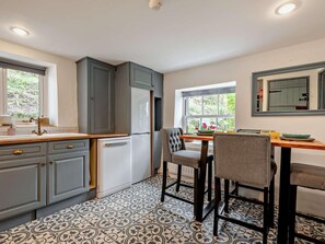 A kitchen with grey cabinets, a white refrigerator, a wooden countertop, and a patterned floor. - 2 Bed in Kendal (oc-94582) (Brigsteer)
