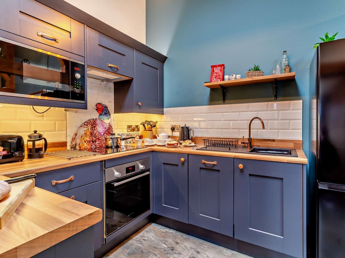 A modern kitchen with a microwave, toaster, coffee maker, and a decorative rooster.