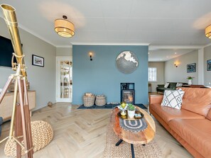 A living room with a telescope, a fireplace, a sofa, and a coffee table. - 3 Bed in Aberaeron (oc-88788) (Aberarth)