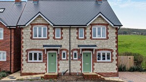 A two-story house with a symmetrical facade, a grey tiled roof, and brick and stone exterior. - 2 Bed in Wareham (oc-94520) (West Lulworth)