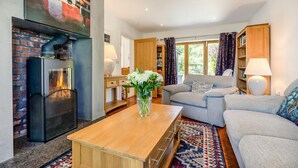 A living room with a fireplace, a sofa, a coffee table, and a bookshelf. - 5 Bed in Telford (oc-72844) (New Works)