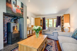 A living room with a fireplace, a sofa, a coffee table, and a bookshelf. - 5 Bed in Telford (oc-72844) (New Works)