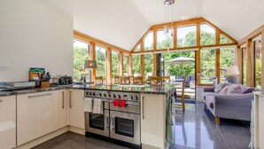 A modern kitchen with a central island, built-in oven, and large windows. - 5 Bed in Telford (oc-72844) (New Works)