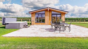 A modern wooden house with a patio, outdoor seating, and a large window. - 2 Bed in St. Andrews (oc-93228) (St Andrews)