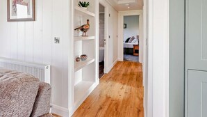 A hallway with white walls, a radiator, a wooden floor, and a bed in the background. - 2 Bed in St. Andrews (oc-93229) (St Andrews)