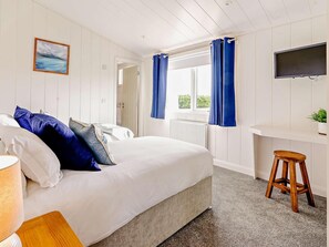 A bedroom with a bed, a desk, a TV, and a window with curtains. - 2 Bed in St. Andrews (oc-93230) (St Andrews)