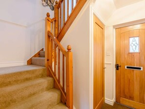 A staircase with wooden railings and carpeted steps leading to a door with a window. - 2 Bed in Hawkshead (oc-llh60) (Hawkshead)