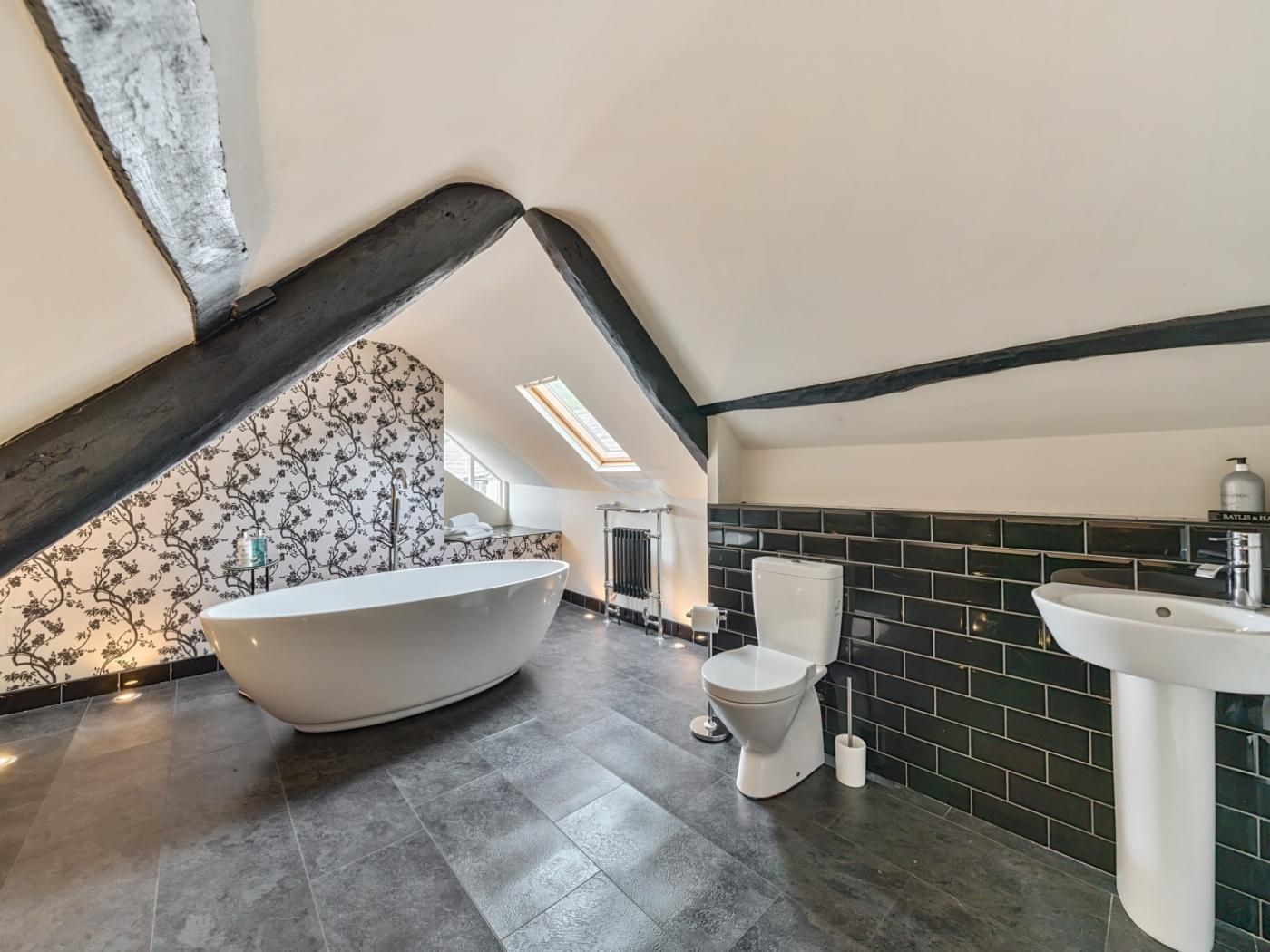 A modern bathroom with a freestanding bathtub, a toilet, and a sink.