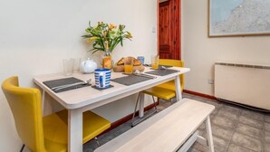 Een eethoek met een tafel gedekt voor twee personen, een klok, een kaart en een radiator.