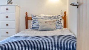 A bed with a striped pillow and a checkered bedspread. - 2 Bed in Bude (oc-54244) (Poundstock)