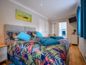 A bedroom with a large bed, a painting of a dragonfly, a mirror, and a television on the wall. - 1 Bed in Goole (oc-77457) (Whitley)