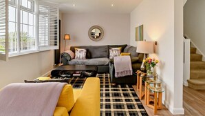 Un salon avec un canapé, une table basse et un tapis à motifs.