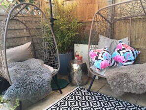 Two hanging chairs with fluffy cushions, a potted plant, and a small table with a drink. - 2 Bed in Hunstanton (oc-slen8) (Hunstanton)