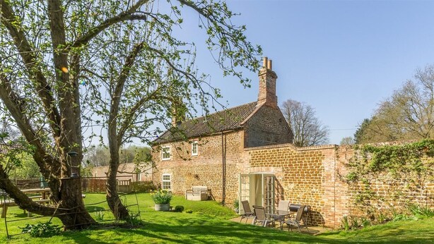 A stone house with a garden, a patio with outdoor furniture, and a chimney. - 3 Bed in King's Lynn (oc-kt097) (Ingoldisthorpe)