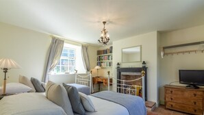 A bedroom with two beds, a fireplace, a television, and a bookshelf. - 3 Bed in King's Lynn (oc-kt097) (Ingoldisthorpe)