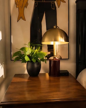 A wooden nightstand with a potted plant and a table lamp. - Magical Retreat Over Morse Creek with Hot Tub (Port Angeles)