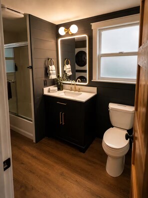 Et moderne badeværelse med vaskebord, toilet og bruseområde.