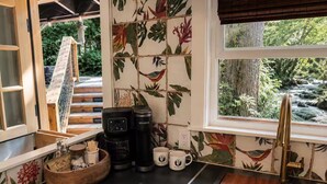 Eine Küche mit einer Kaffeemaschine, Tassen und einer Holzkugel auf der Arbeitsplatte.