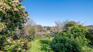 A garden pathway leading to a house with a stone wall and a blue chair. - 2 Bed in Kippford (oc-81129) (Colvend)