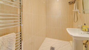 Ein Badezimmer mit Dusche, Waschbecken und Handtuchhalter.