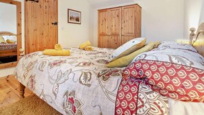 Ein Schlafzimmer mit einem Bett, einem Holzschrank und einem Spiegel.