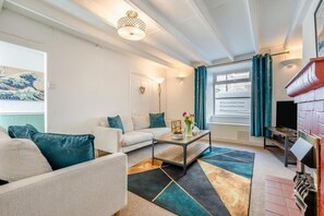 A modern living room with a sofa, coffee table, and decorative items. - 2 Bed in Padstow (oc-88178) (Padstow)