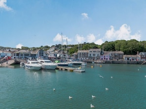 A harbor with boats docked, a pier, and buildings along the waterfront.