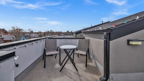 A rooftop terrace with a table and chairs, a view of the neighborhood, and a clear sky. - Rino Private Rooftop  - Art District Location. Walk To Everything! (Denver)