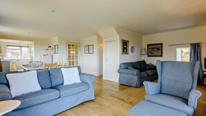 A spacious living area with a sofa set, a dining table, and a kitchen in the background. - 4 Bed in Scourie (oc-ca399) (Scourie More)