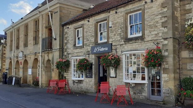 A stone building with a sign reading 'La Trattoria,' featuring a traditional architectural style with arched windows and a bell tower. - 2 Bed in York (oc-81052) (Helmsley)