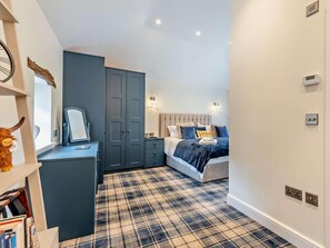 Une chambre dotée d’un lit, d’un bureau, d’une armoire et d’un terminal d’enregistrement.