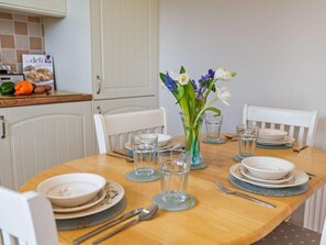 A dining table set with plates, glasses, and cutlery, surrounded by chairs. - 3 Bed in Christchurch (oc-94605) (Bransgore)