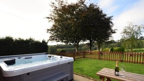 Ein Whirlpool mit Stufen, ein Holztisch und eine Champagnerflasche.
