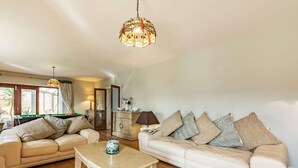 A living room with two sofas, a coffee table, a lamp, and a decorative hanging light fixture. - 5 Bed in Bicester (oc-87367) (Chesterton)