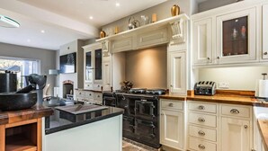 A modern kitchen with white cabinetry, a central island, a stove, and a toaster. - 5 Bed in Bicester (oc-87367) (Chesterton)