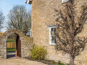 A stone building with a wooden door, a window, and a tree in front. - 5 Bed in Bicester (oc-87367) (Chesterton)