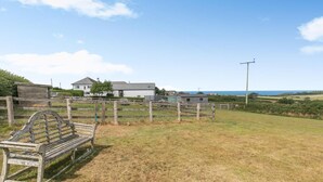 A rural property with a wooden bench, a fence, and a house in the background. - 2 Bed in Bideford (oc-swabr) (Higher Clovelly)