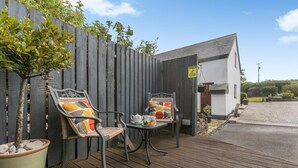 A patio area with two chairs, a table, and a potted plant. - 2 Bed in Bideford (oc-swabr) (Higher Clovelly)