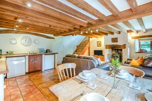 A spacious living area with a wooden ceiling, a dining table set for four, and a kitchen with a dishwasher and sink. - 2 Bed in Penrith (oc-79466) (Kirkland)