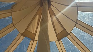 A tent-like structure with a central pole and multiple fabric panels. - High End Glamping Tent! Amazing Mountain Scenery! Kananaskis country! Privacy! (Calgary)