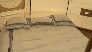 A bed with a white and black geometric pattern, a circular window, and a tent-like structure. - High End Glamping Tent! Amazing Mountain Scenery! Kananaskis country! Privacy! (Calgary)